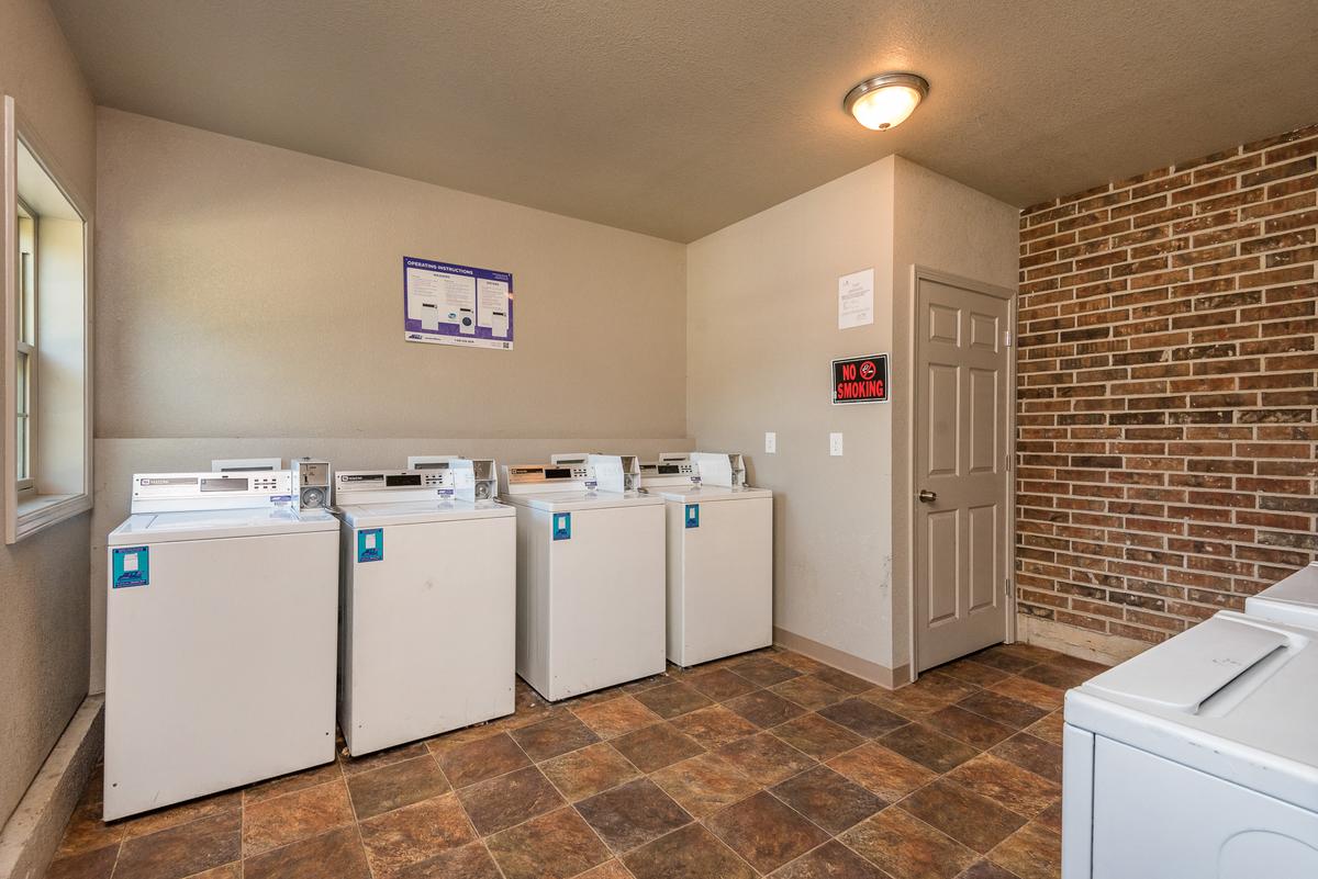 A row of washing machines lined up in a laundry room.