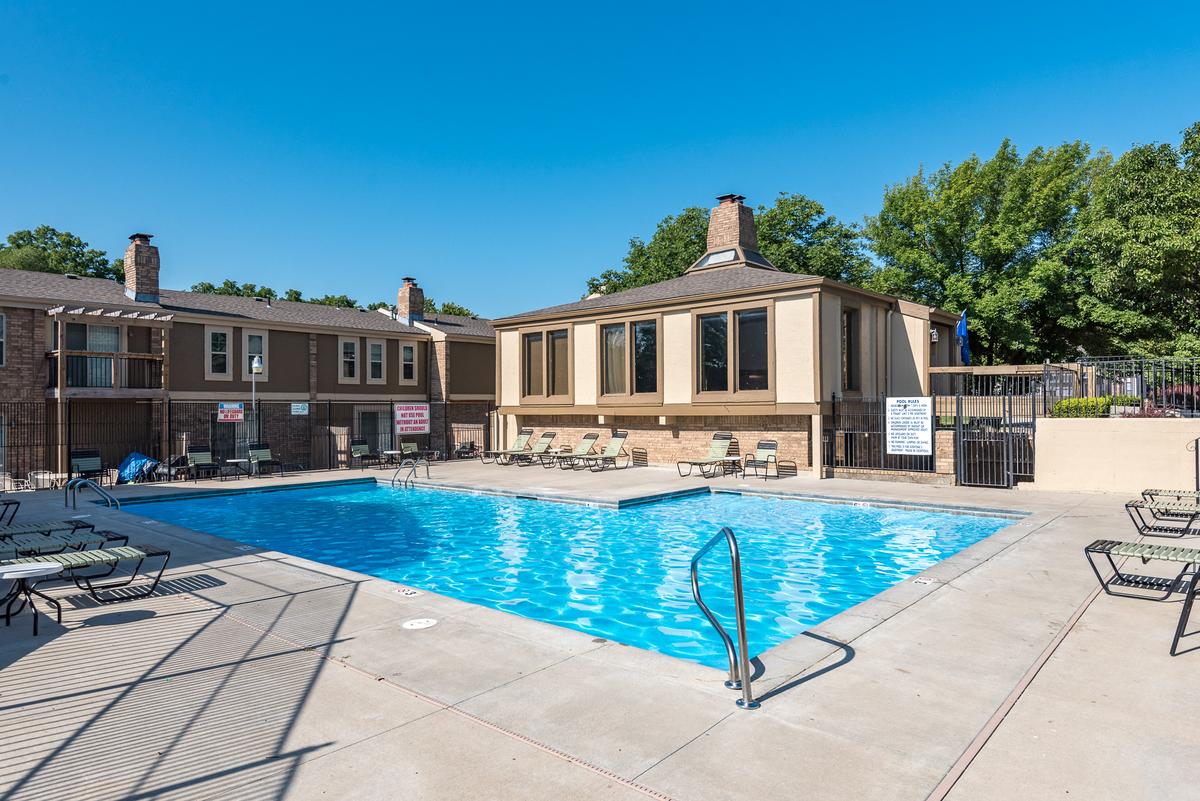 A pool area with a building in the background.